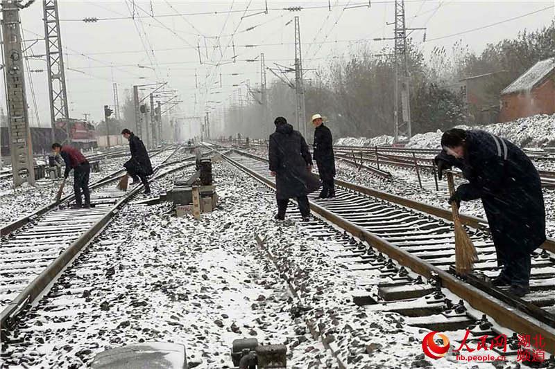 組織工作人員走上線路掃雪除冰。（郭松  攝）